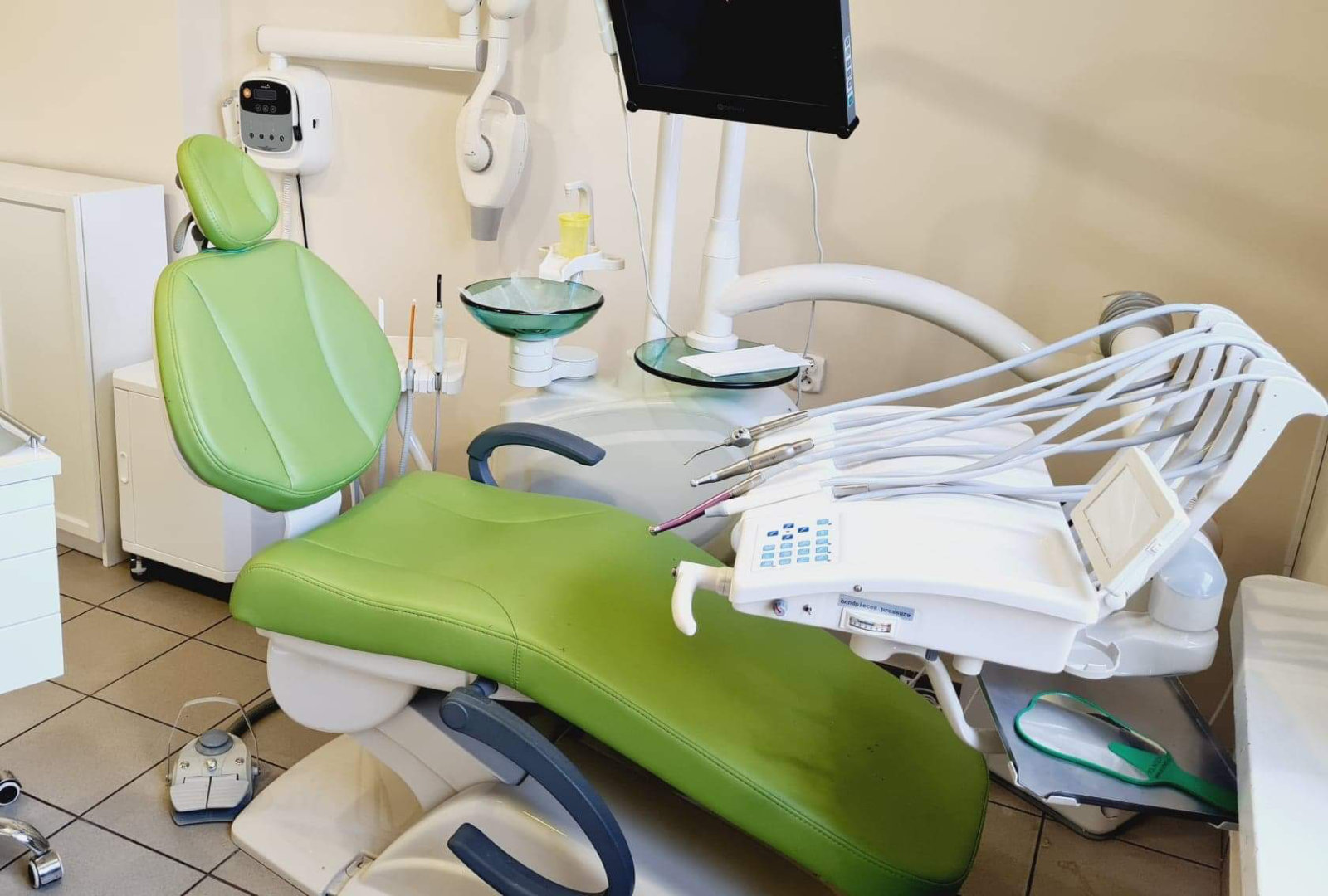 Fotel w gabinecie dentystycznym z widoczną aparaturą dentystyczną.
