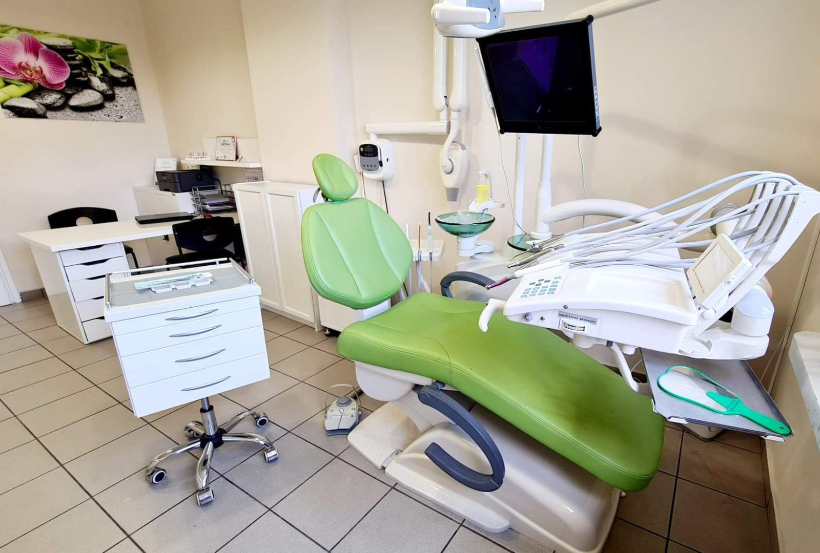 Gabinet dentystyczny z pełnym wyposażeniem oraz biurkiem i krzesłami.